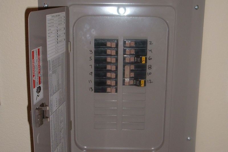 Open residential circuit breaker panel with breakers visible